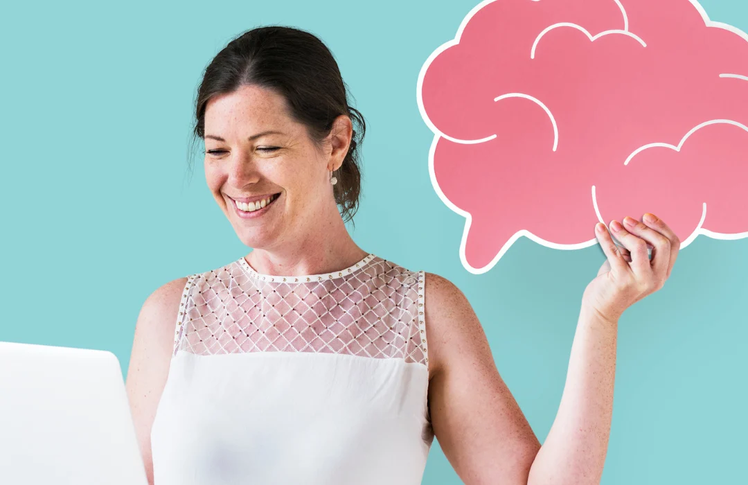 mujer sujetando cerebro viendo laptop