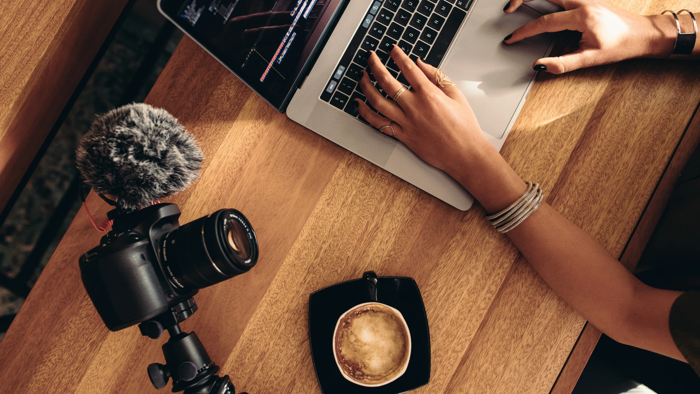 manos de mujer sobre laptop y cámara de fotos a un lado manos de mujer sobre laptop y cámara de fotos a un lado